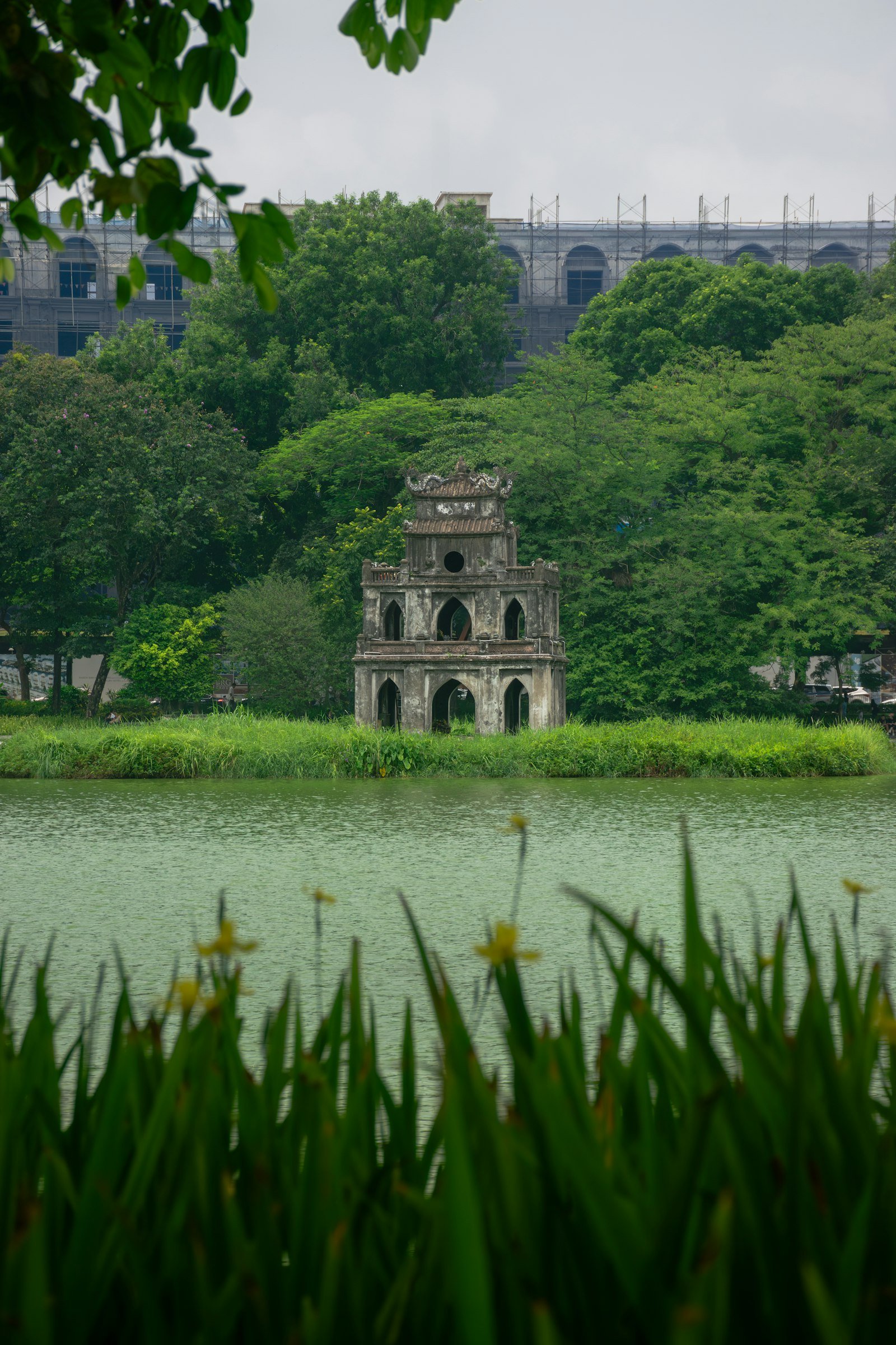 A large landmark building beside a green lawn in Hanoi