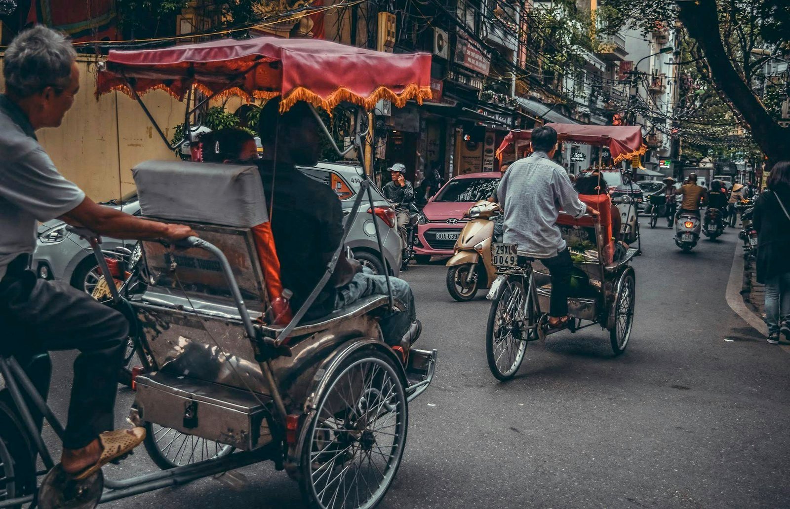 A man riding a cyclo pedicab on a street
