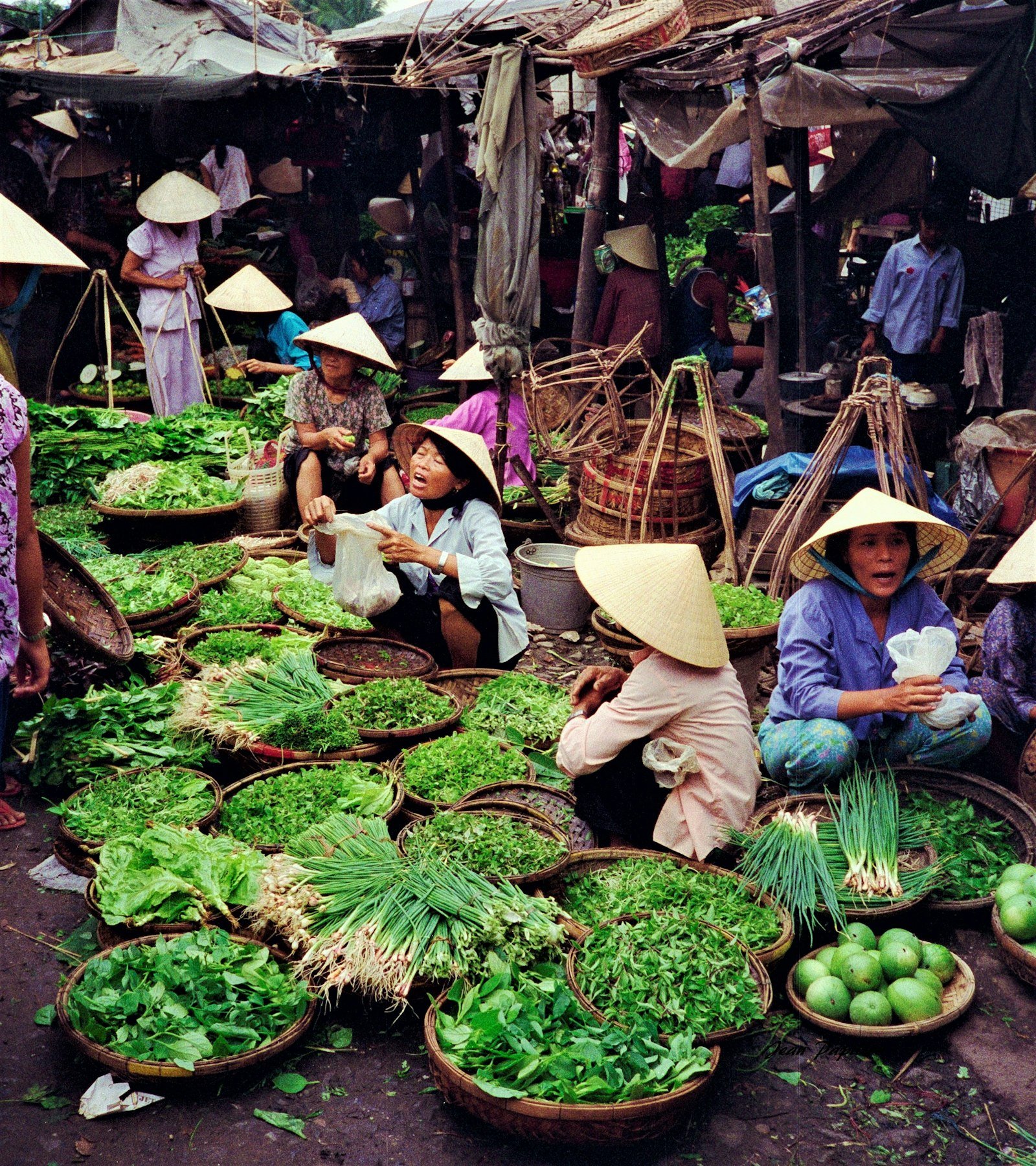 People sitting on small stools at a street market